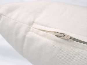 Close up of consealed dunlap zipper constrcution on pillow with double-lapped construction and secure zipper pull pocket