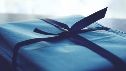 a present wrapped in blue paper with a bow