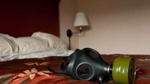 A gas mask sits on a memory foam mattress