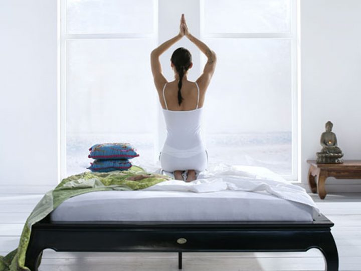 woman doing yoga on a bed